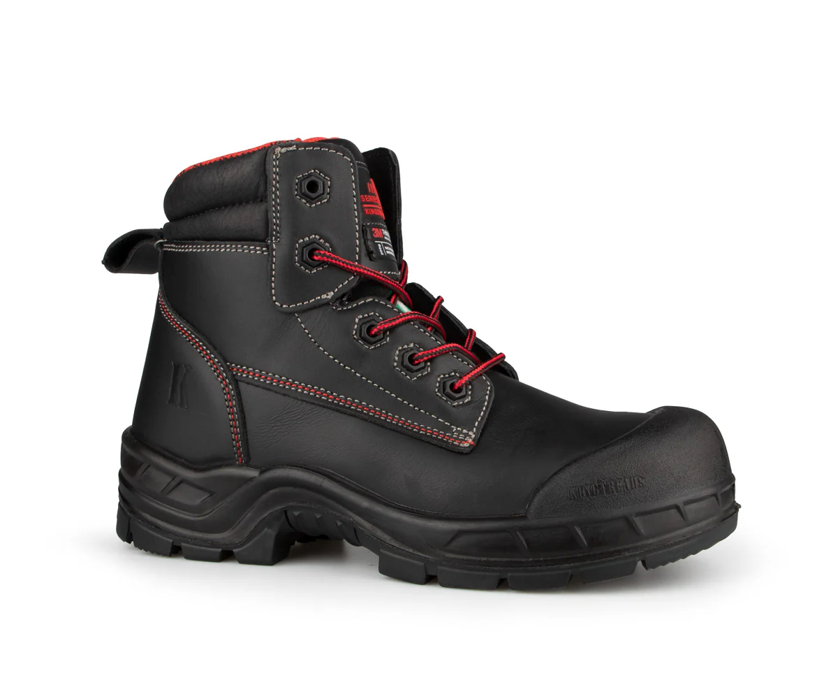 Une botte de travail en cuir noir avec coutures rouges et lacets rehaussés de rouge, dotée d'un bout renforcé, d'une semelle crantée robuste et d'un soutien de cheville rembourré. La botte est positionnée face vers la droite sur fond blanc.