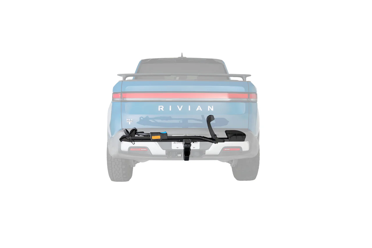 Un camion Rivian bleu est montré de l'arrière avec un porte-vélos PORTE-VÉLO ROCKY MOUNTS HIGHNOON 1.25" (1 VÉLO) attaché à son attelage, sur un fond blanc.