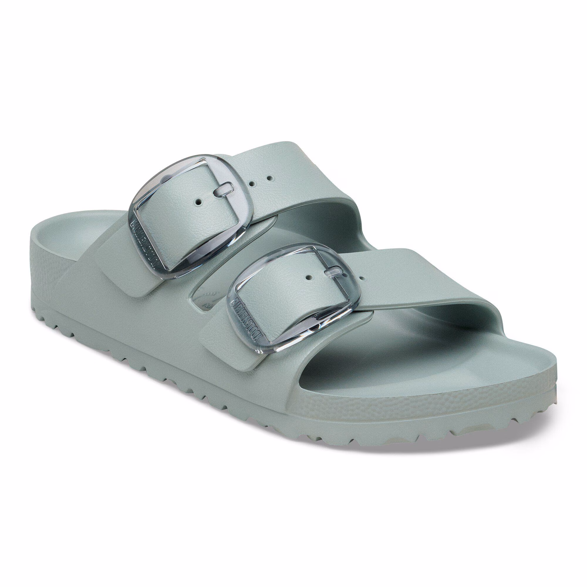 La sandale ARIZONA BIG BUCKLE EVA N, de couleur vert clair, se compose de deux larges lanières, chacune ornée d'une grande boucle argentée, et d'une semelle texturée. La sandale est présentée en biais sur un fond blanc.
