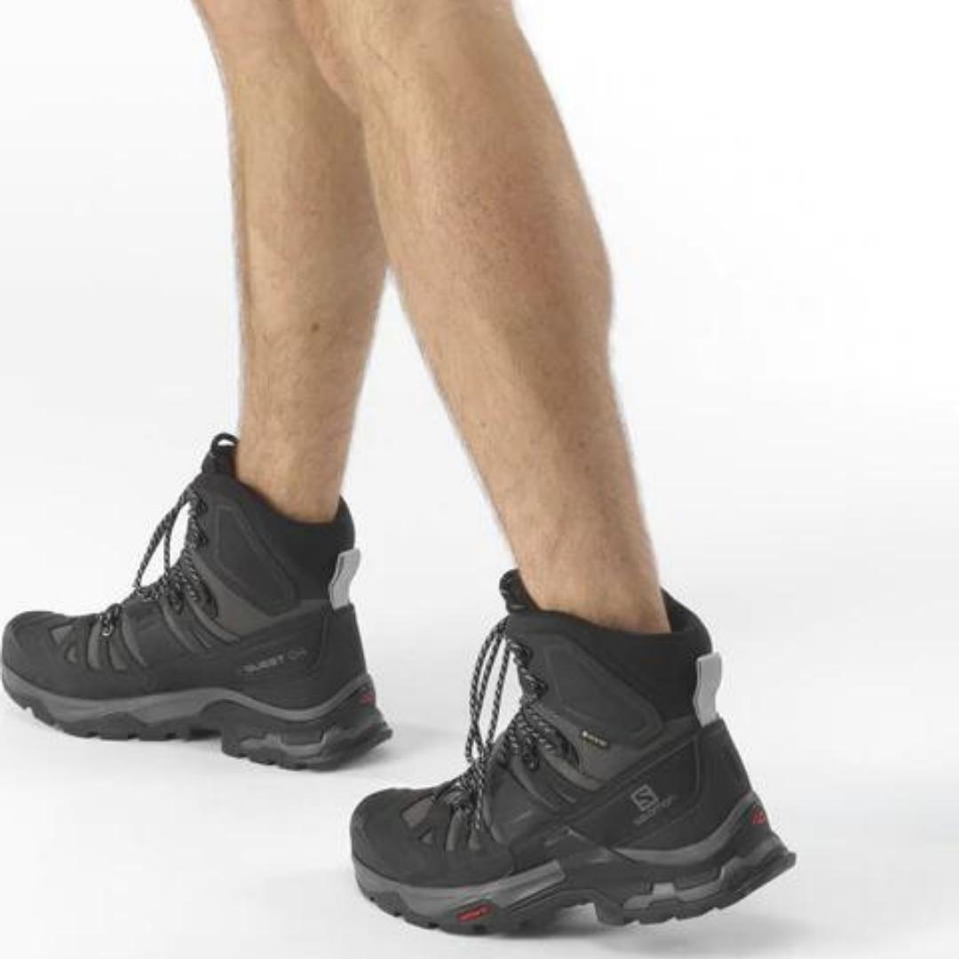botte de randonnée Salomon Quest 4 gtx pour homme couleur black vu d'un homme qui porte les bottes en studio