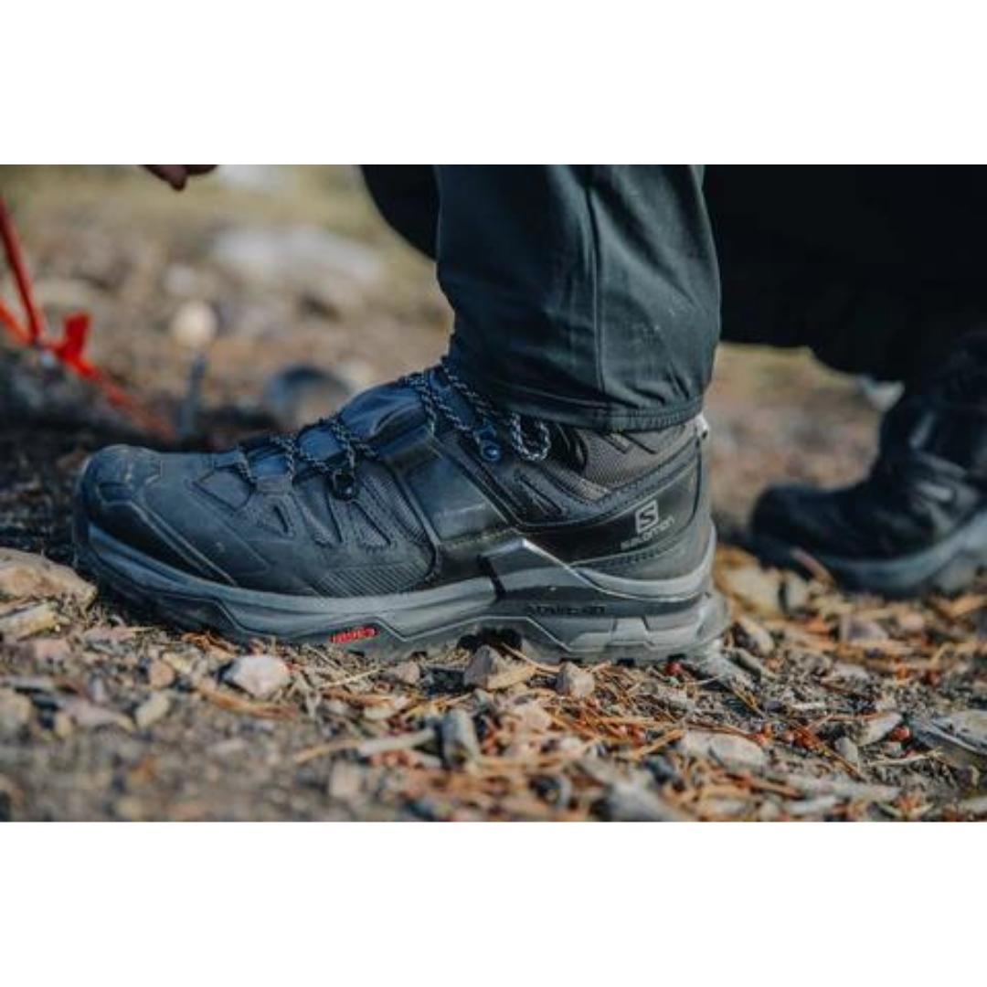 botte de randonnée Salomon Quest 4 gtx pour homme couleur black vu d'un homme qui porte les bottes en nature