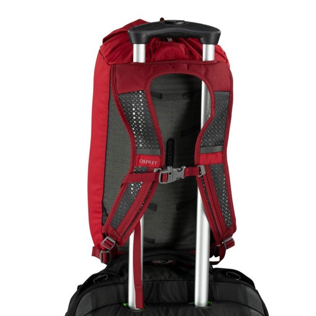 SAC À DOS OSPREY DAYLITE CINTRÉ ATTACHÉ A UNE POIGNÉE DE TRANSPORT D'UNE VALISE VUE DE LA SANGLE D'ATTACHE BOUCLÉE