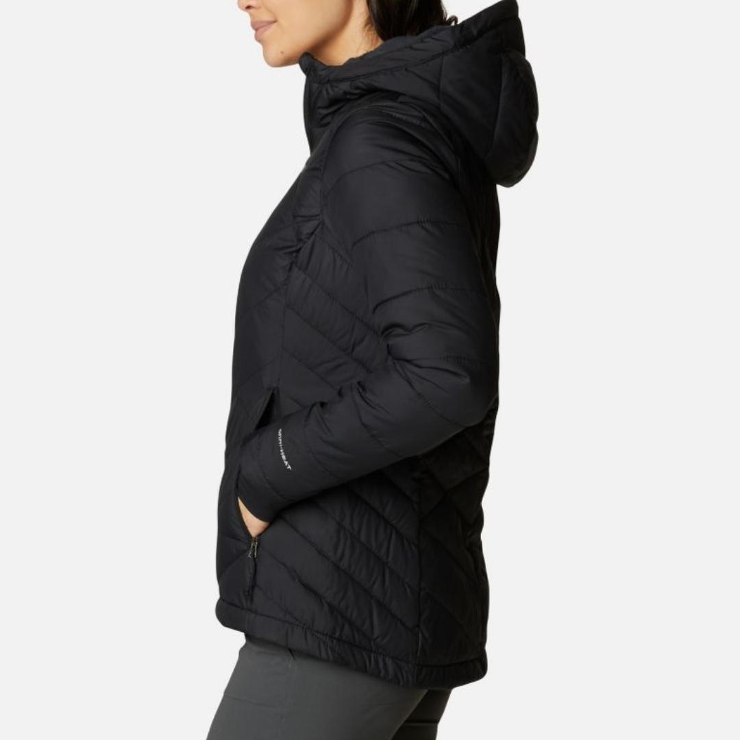 MANTEAU COLUMBIA HEAVENLY HOODED POUR FEMME COULEUR BLACK PORTÉ PAR UNE FEMME VUE DE PROFIL GAUCHE AVEC UNE MAIN DANS LA POCHE LATÉRALE POUR LES MAINS
