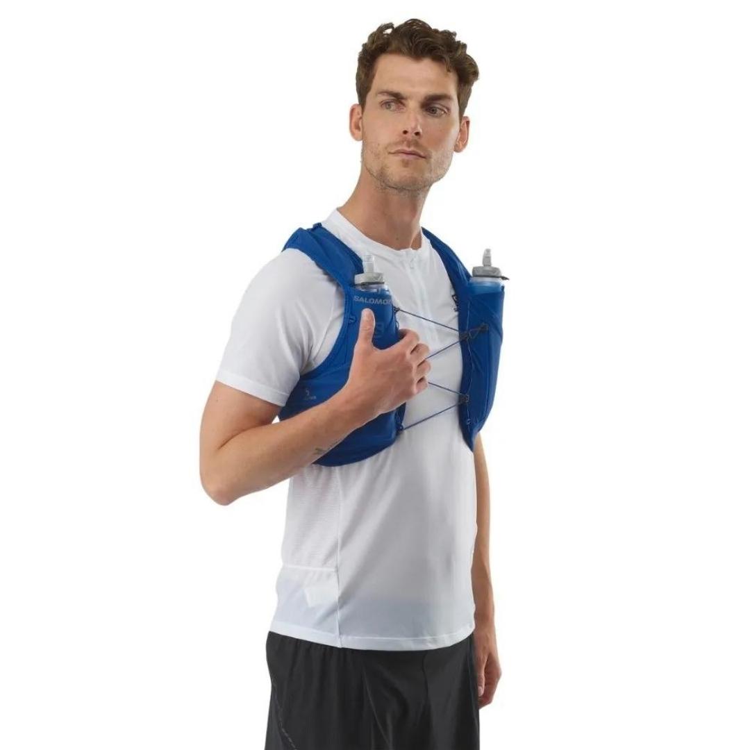 VESTE D'HYDRATATION SALOMON ADV SKIN 5 AVEC BOUTEILLES POUR HOMME couleur NAUTICAL BLUE / EBONY / WHITE porté par un homme vu de profil il tien un ebouteille d'eau dans sa poche de poitrine