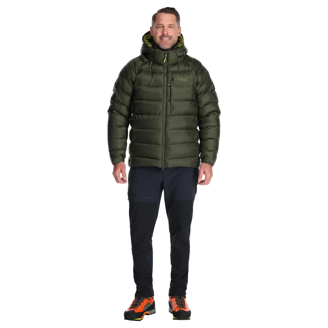 MANTEAU ISOLÉ EN DUVET RAB AXION PRO POUR homme couleur army porté par un homme vu de face cordon de serrage du capuchon visible manteau vert armé et détails vert lime