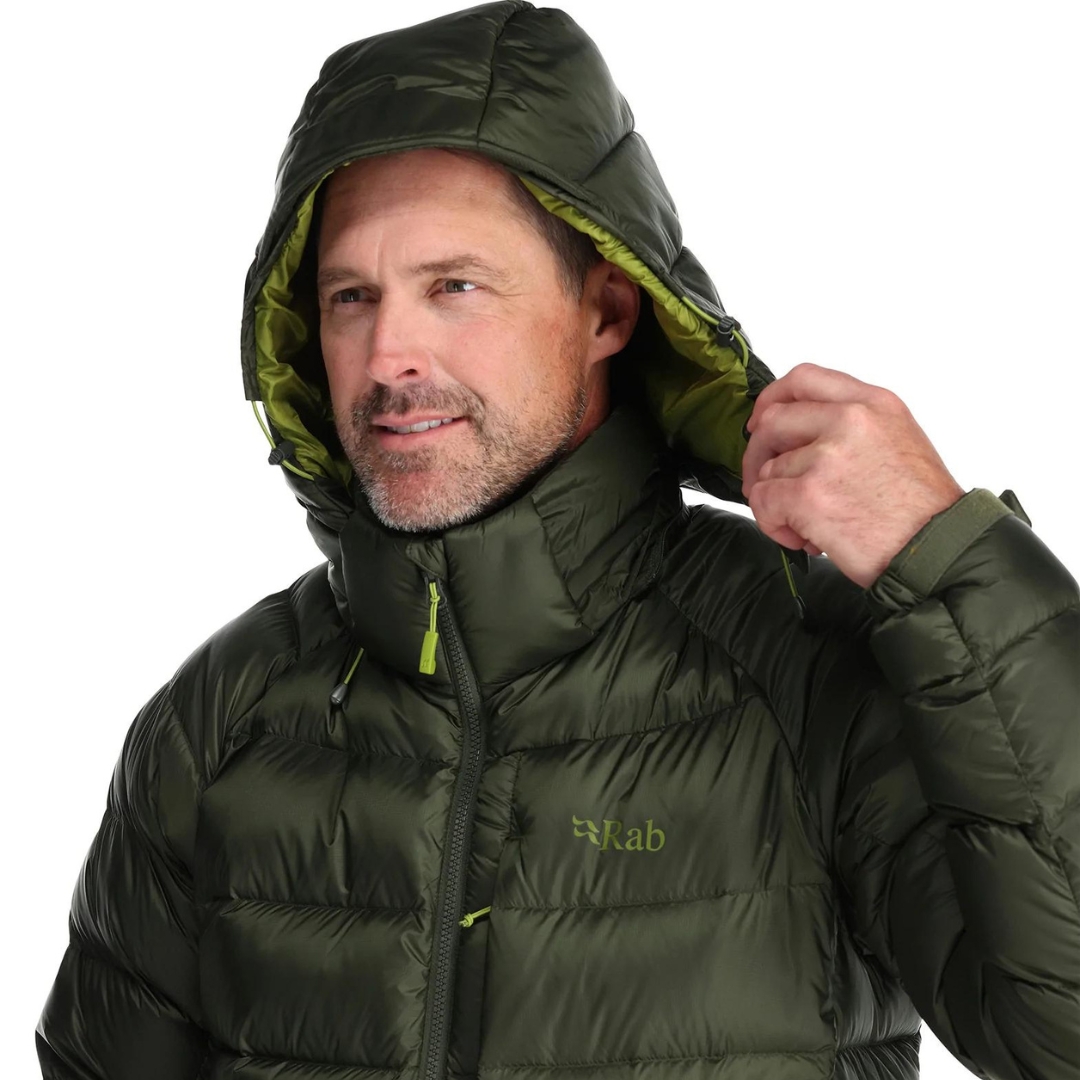 MANTEAU ISOLÉ EN DUVET RAB AXION PRO POUR homme couleur army porté par un homme qui montre le capuchon amovible doublé et compatible avec les casques de protection