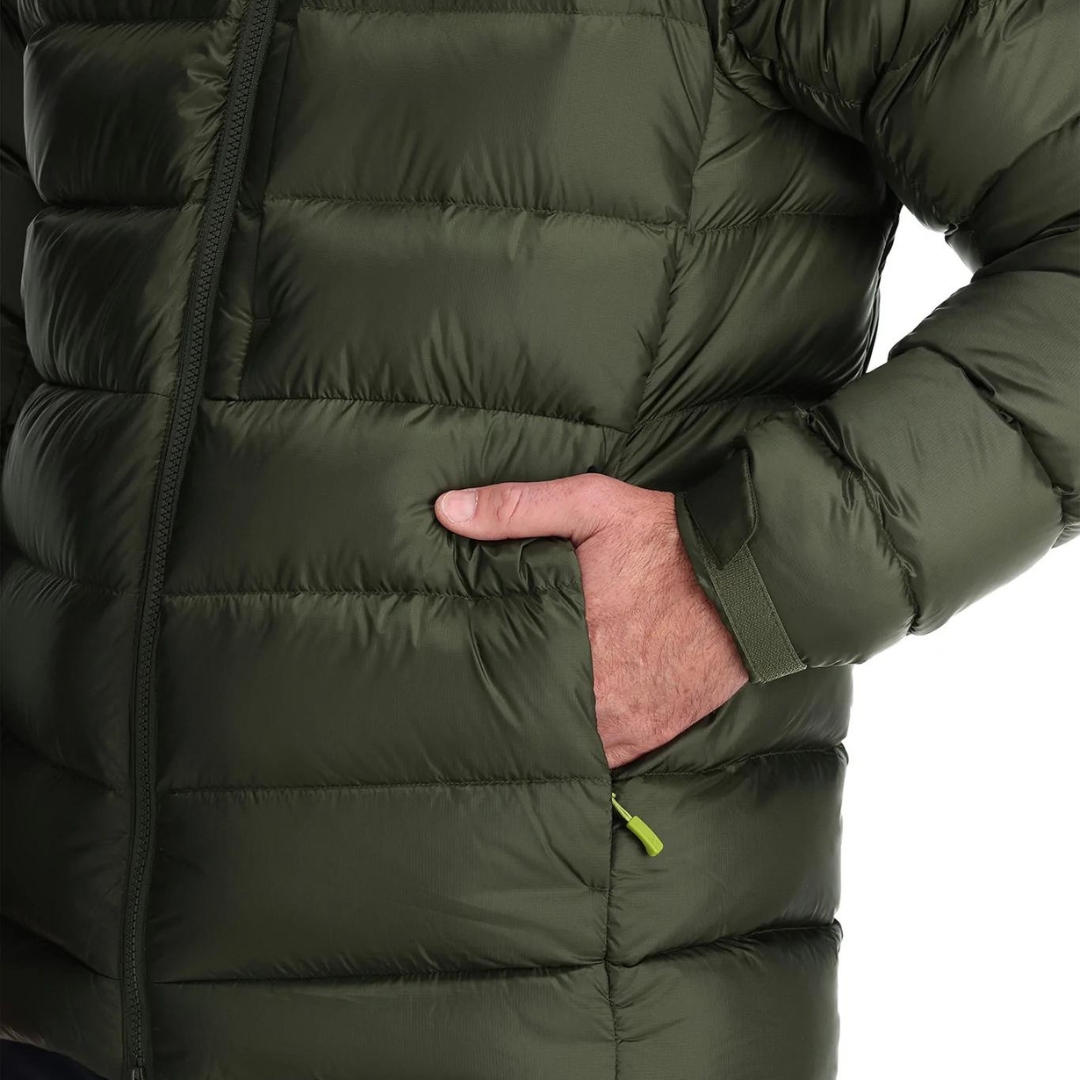 MANTEAU ISOLÉ EN DUVET RAB AXION PRO POUR homme couleur army porté par un homme qui a une main dans la poche latérale à main on voit la fermeture à glissière de celle-ci