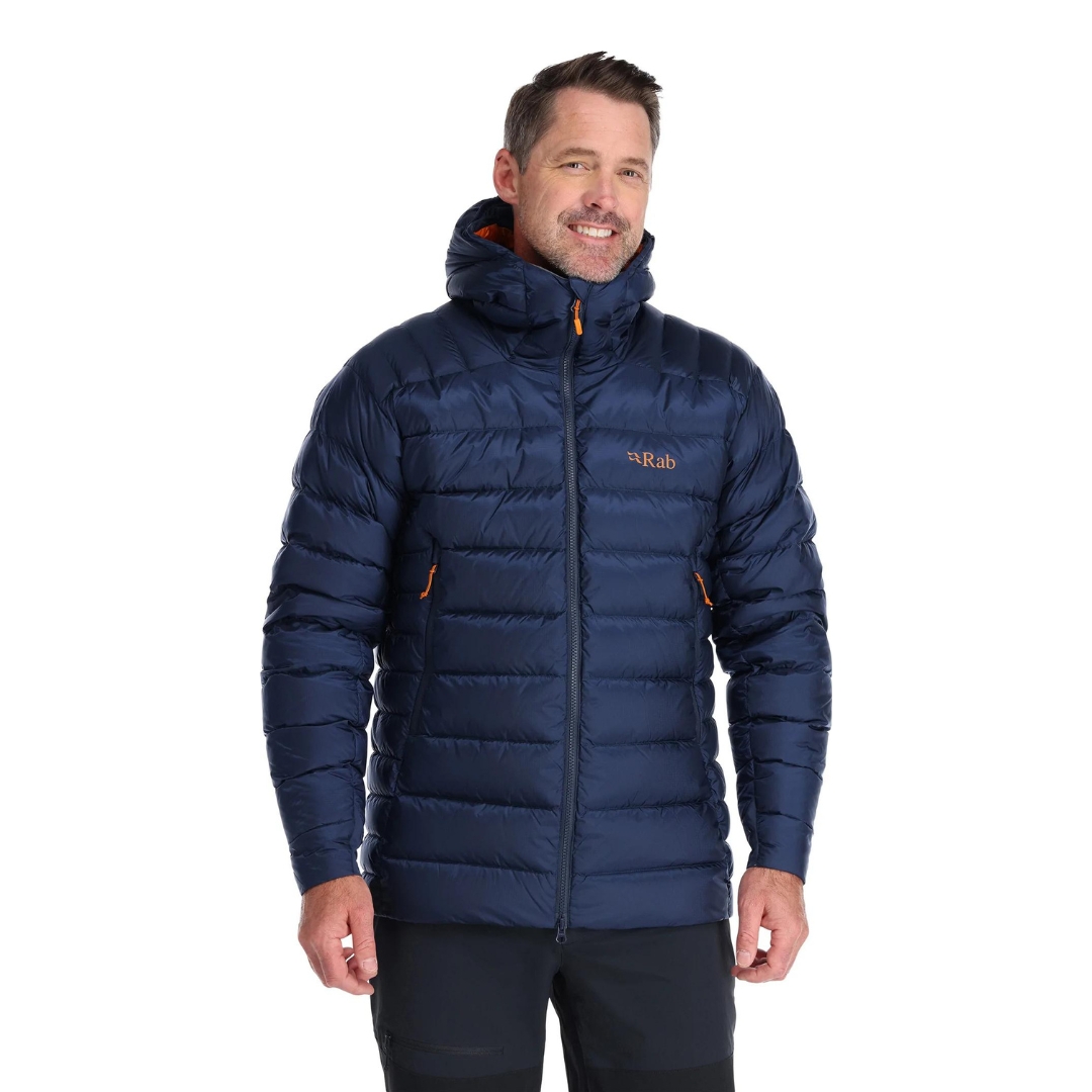 MANTEAU ISOLÉ EN DUVET RAB ELECTRON PRO POUR HOMME couleur deep ink porté par un homme vu de face avec le manteau bleu marin logo rb côté poitrine gauche en orange visible ainsi que la capuche isolée