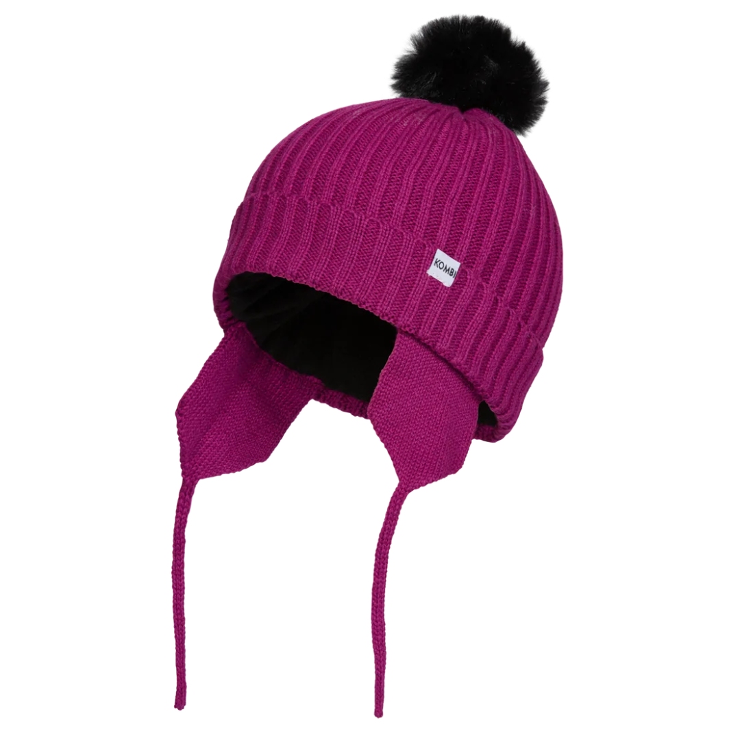 TUQUE PÉRUVIENNE KOMBI SIMPLY POUR ENFANT COULEUR POP ORCHIDÉE VUE DE PROFIL GAUCHE DE LA TUQUE ROSE FUSCHIA AVEC POMPOM NOIR OREILLE À CORDONS ET ÉCUSSON KOMBI VISIBLES