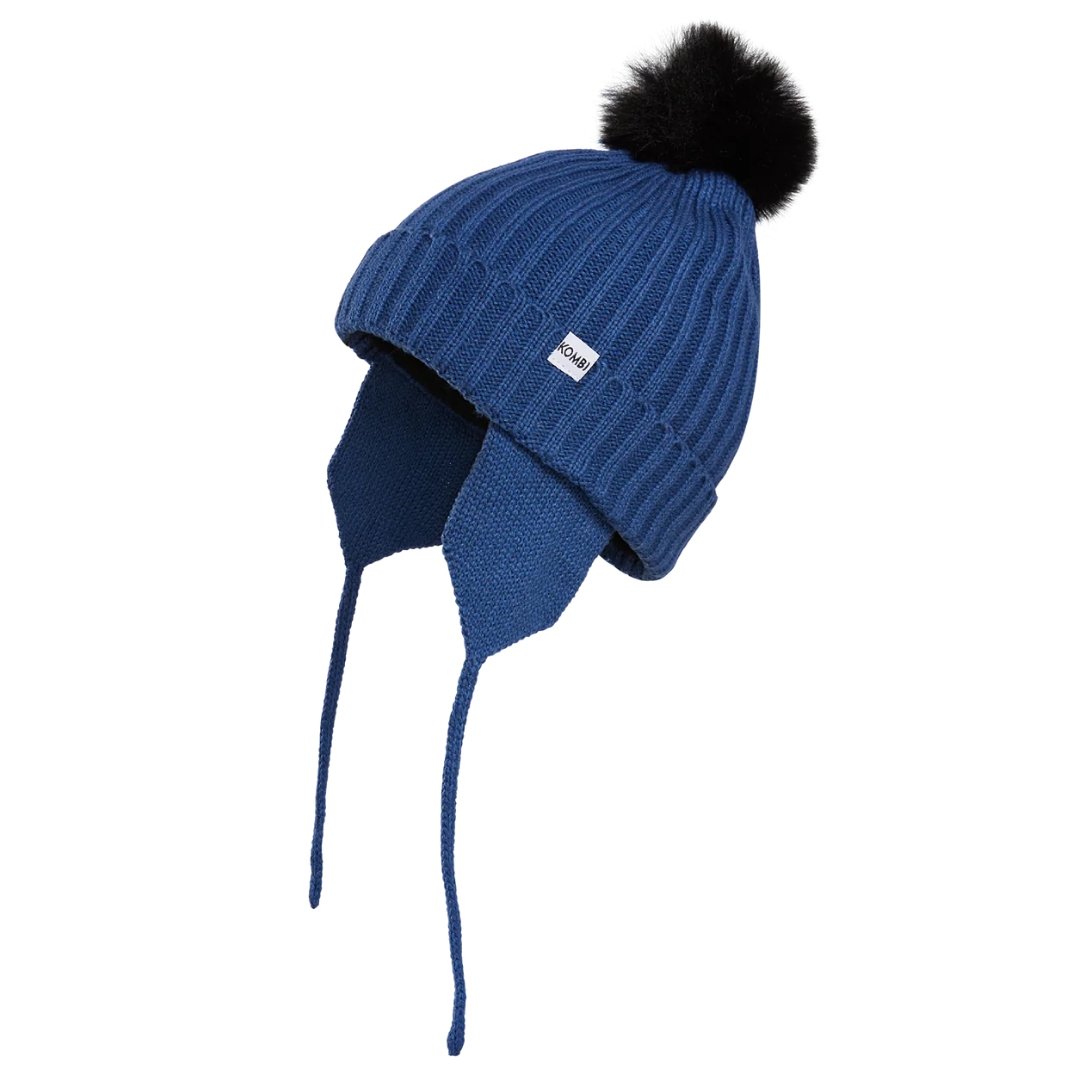 TUQUE PÉRUVIENNE KOMBI SIMPLY POUR ENFANT COULEUR BLEU RICHE VUE DE PROFIL GAUCHE DE LA TUQUE BLEU FONCÉE AVEC POMPOM NOIR OREILLE À CORDONS ET ÉCUSSON KOMBI VISIBLES