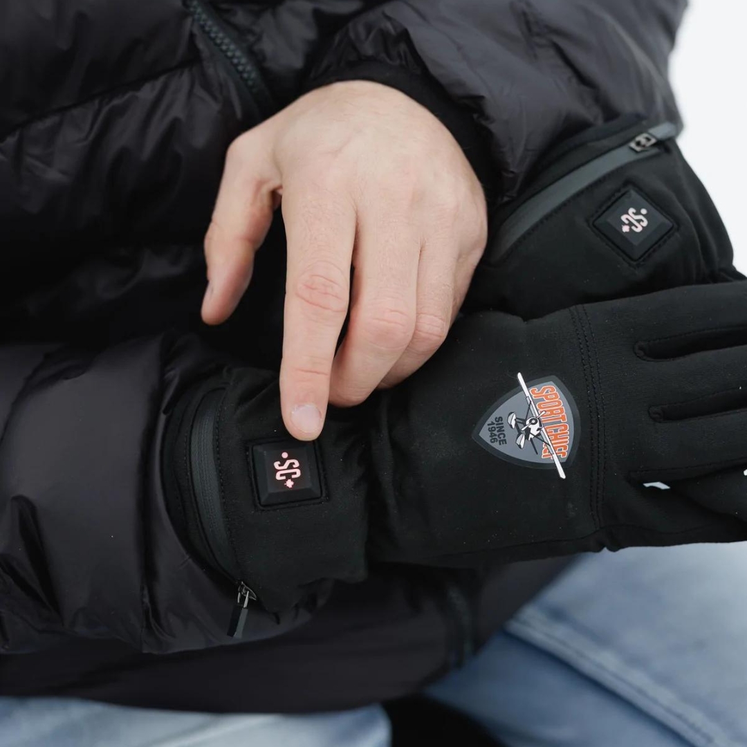 gant léger chauffant sportchief pour adulte vue d'un homme qui utilise les gants et qui montre l'interrupteur au dessus de la main