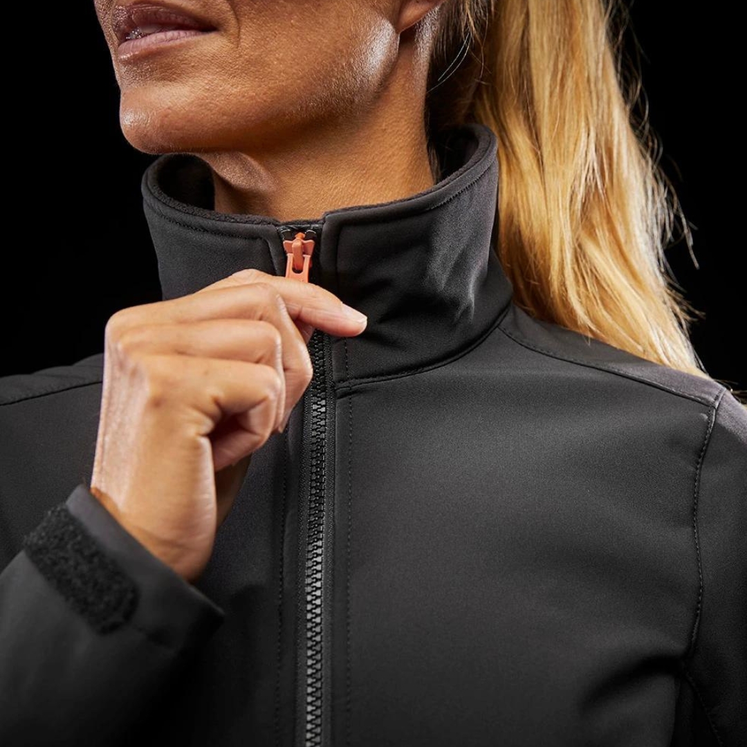 MANTEAU DE TRAVAIL HELLY HENSEN LUNA SOFTSHELL POUR FEMME couleur black porté par une femme gros plan sur le haut du manteau elle ferme la fermeture éclair principale