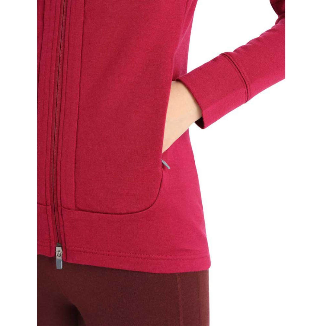 CHANDAIL À CAPUCHE ICEBREAKER QUANTUM III À FERMETURE À GLISSIÈRE POUR femme COULEUR CHERRY/ESPRESSO PORTÉ PAR UNE FEMME GROS PLAN SUR LA POCHE LATÉRALE À FERMETURE À GLISSIÈRE LA FEMME A UNE MAIN DANS LA POCHE