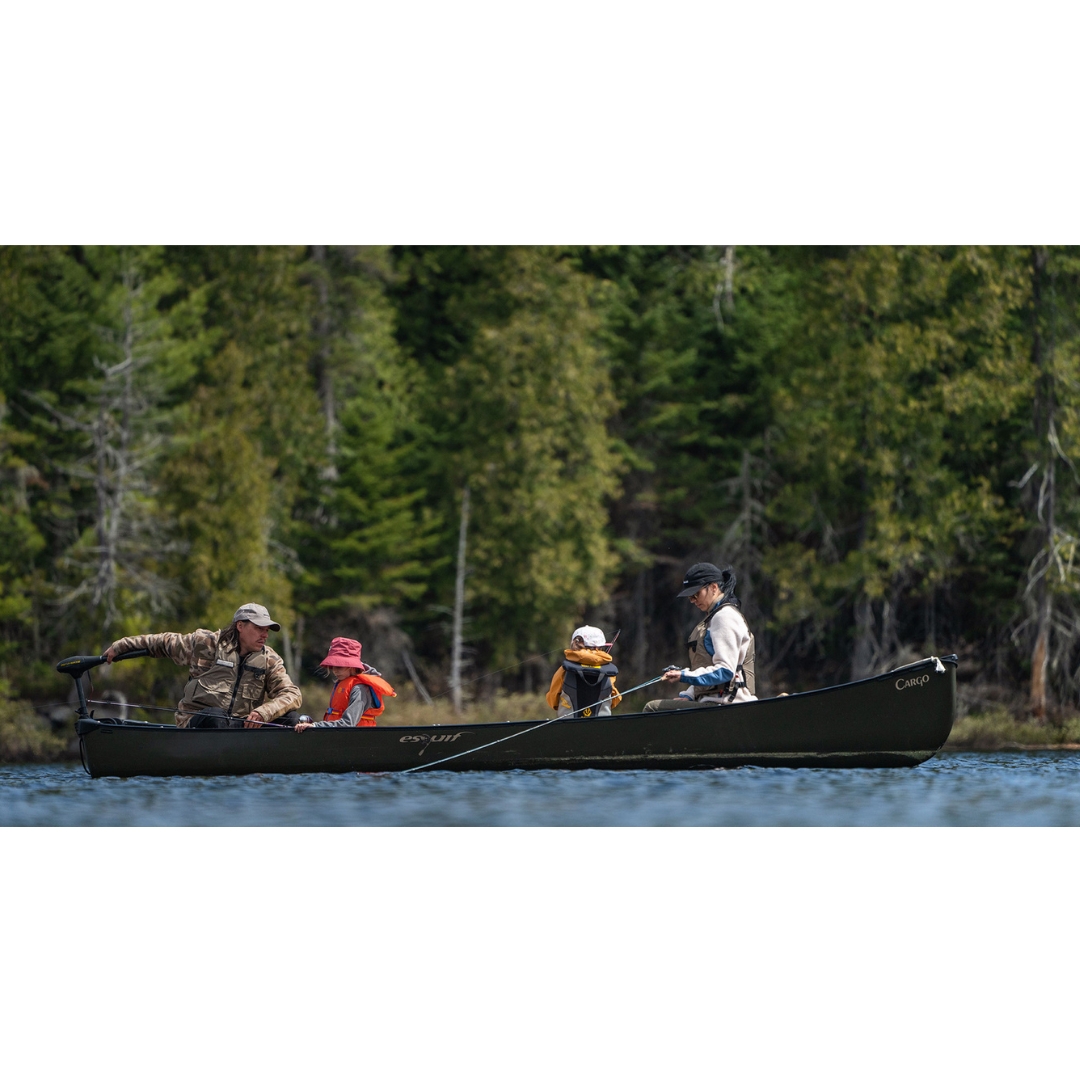canot esquif cargo couleur vert utilisé par une famille à la peche sur un lac