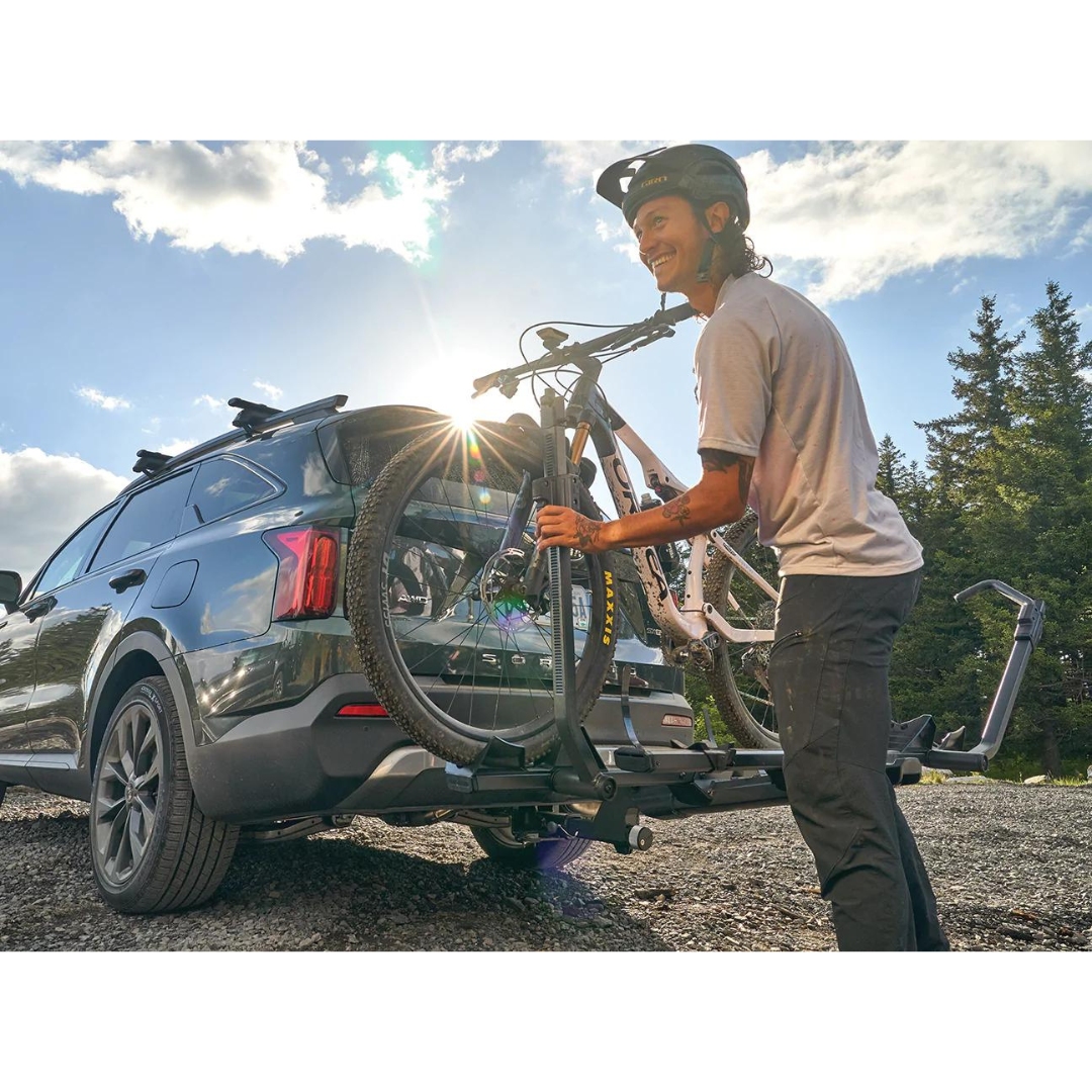 SUPPORT À VÉLO YAKIMA STAGE TWO 2PO instalé sur une voiture avec un vélo une personne installe son vélo sur le support