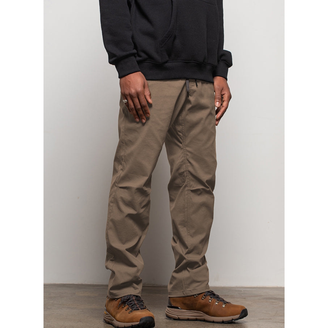 PANTALON 686 EVERYWHERE POUR HOMME couleur tobacco proté par un homme vu de face de la taille aux pieds avec le pantalon bas retourné et couture rouge visible