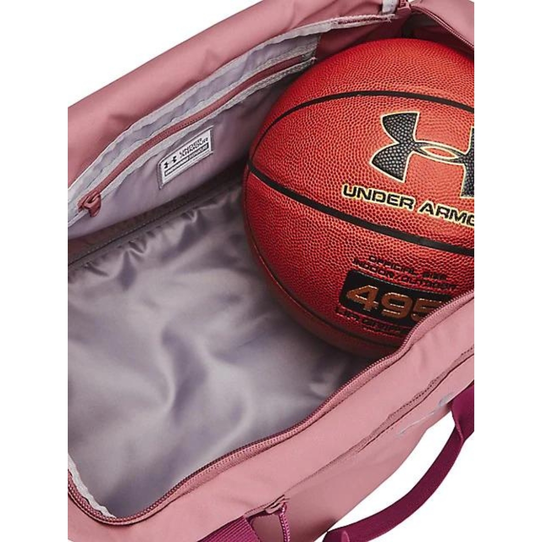SAC DE SPORT UNDER ARMOUR UNDENIABLE SIGNATURE POUR FEMME couleur 697-PINK ELIXIR/CHARGED CHERRY/METALLIC vue de l'intérieur du compartiment principal avec un ballon de basket