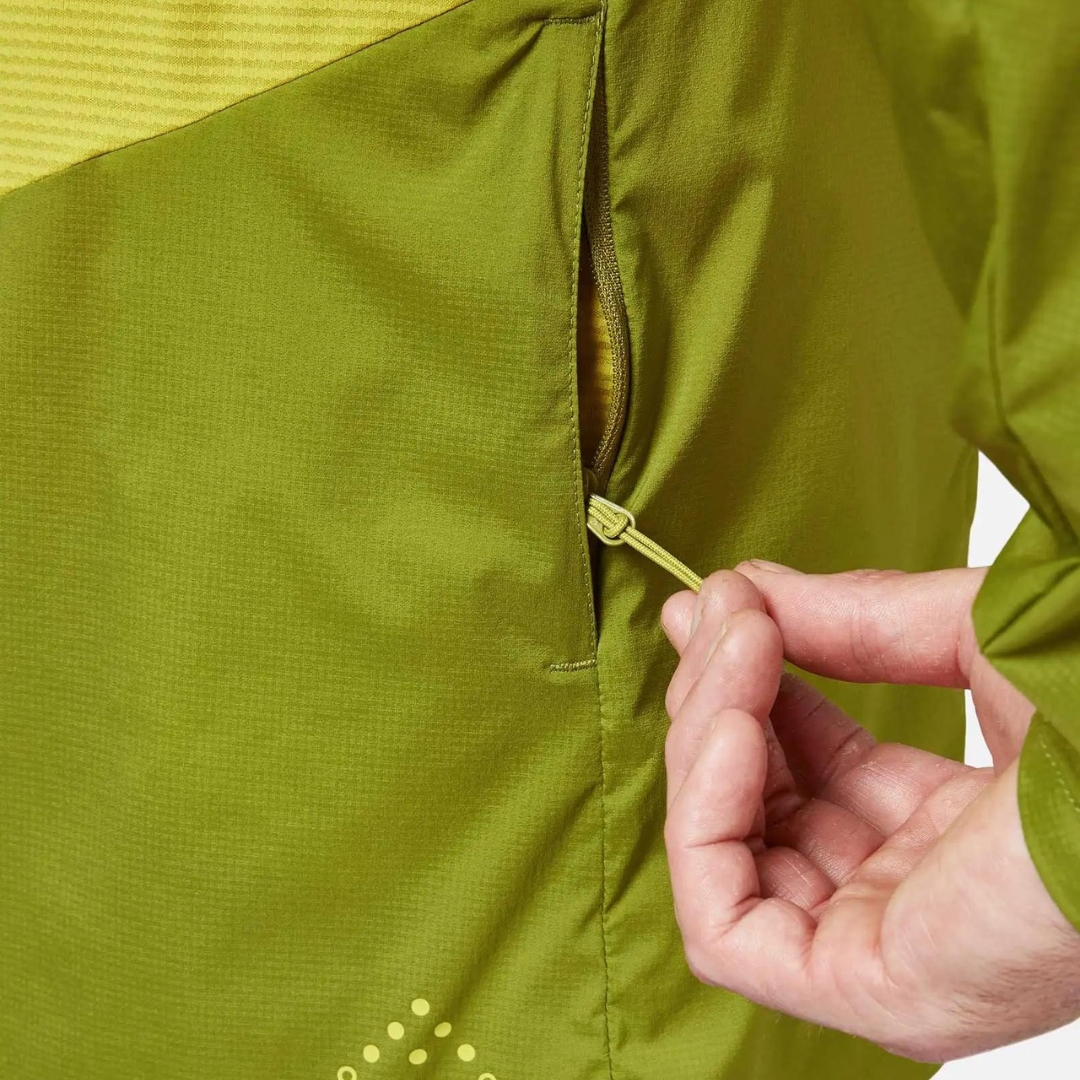 MANTEAU COUPE VENT RAB WINDVEIL POUR HOMME porté par un homme qui montre la fermeture éclaire de la poche latérale pour les mains