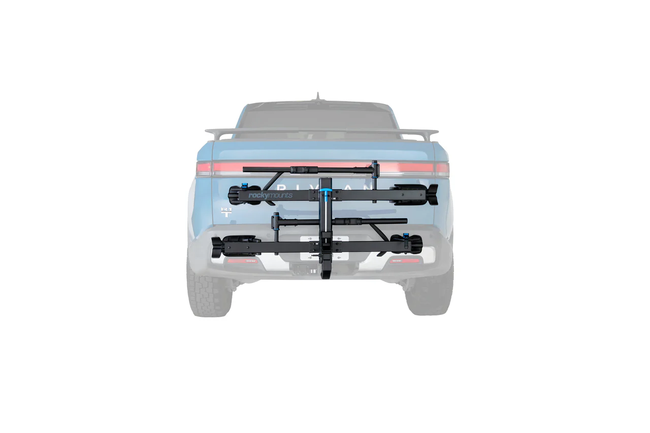Vue arrière d'une camionnette bleu clair avec un porte-vélos MONORAIL 2" en métal noir attaché à son attelage, sur fond blanc.