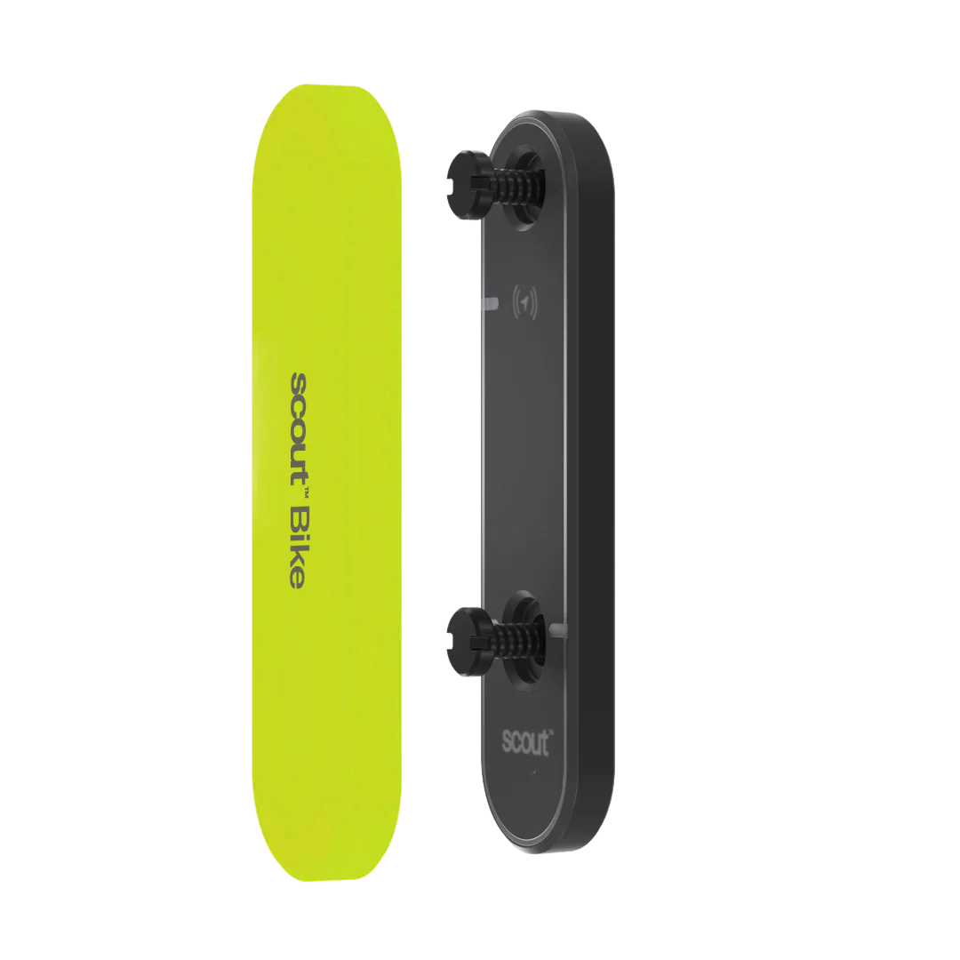 Un dispositif rectangulaire jaune étiqueté "scout : Bike" à côté d'une plaque arrière noire avec des vis de fixation, les deux étant debout.