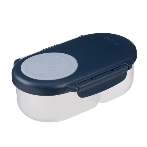 La SNACKBOX est une boîte à repas rectangulaire en plastique, dotée d'un couvercle bleu marine rehaussé d'un détail circulaire gris clair et d'un loquet de fermeture sécurisé à l'avant.