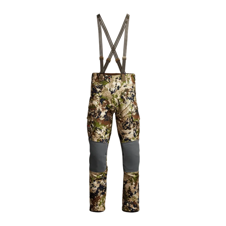 Pantalon de chasse camouflage avec bretelles, renforts gris aux genoux et multiples poches, conçu pour les activités de plein air en milieu naturel et forestier.