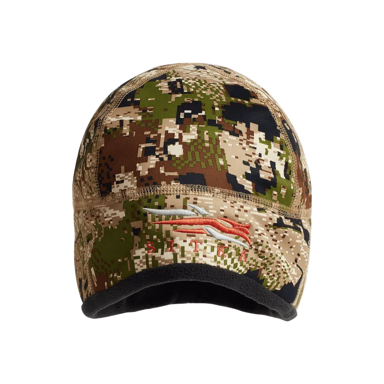 Un bonnet à motif camouflage avec différentes nuances de vert, marron, tan et noir, avec un logo brodé en orange et gris sur le devant.