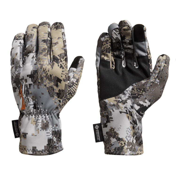 Une paire de gants à motif camouflage montrée de l'arrière et des côtés de la paume, avec des couleurs camouflage numérique et un matériau noir texturé sur les paumes. Des étiquettes sont attachées aux poignets.