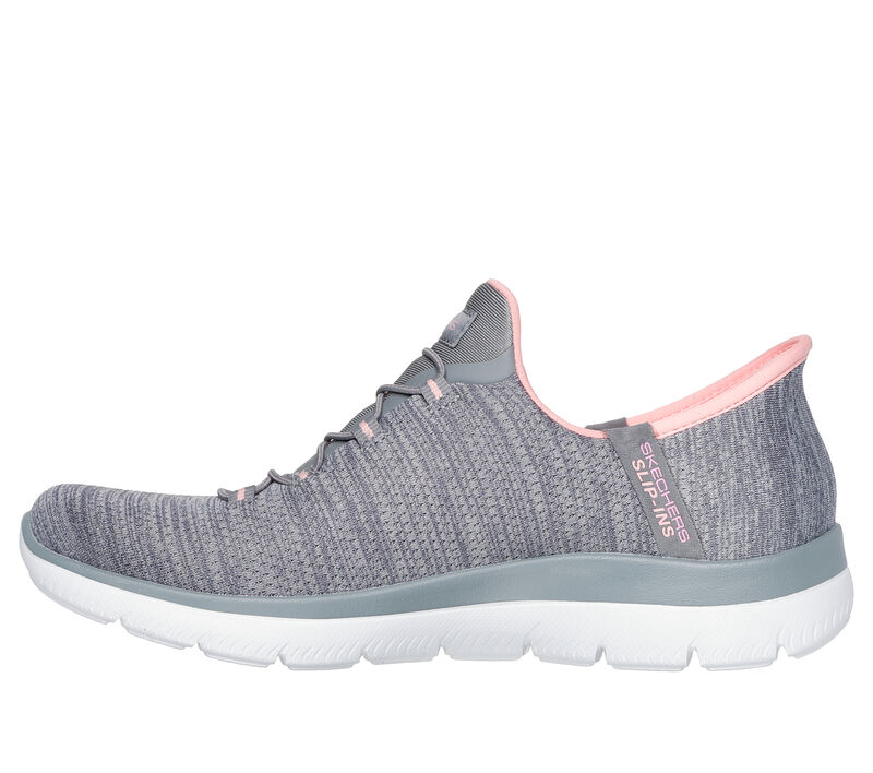 Baskets grises à enfiler avec tige en tissu texturé, touches de rose clair et lacets gris doux. Elles sont dotées d'une semelle blanche coussinée et d'un logo « Skechers » près de la cheville.