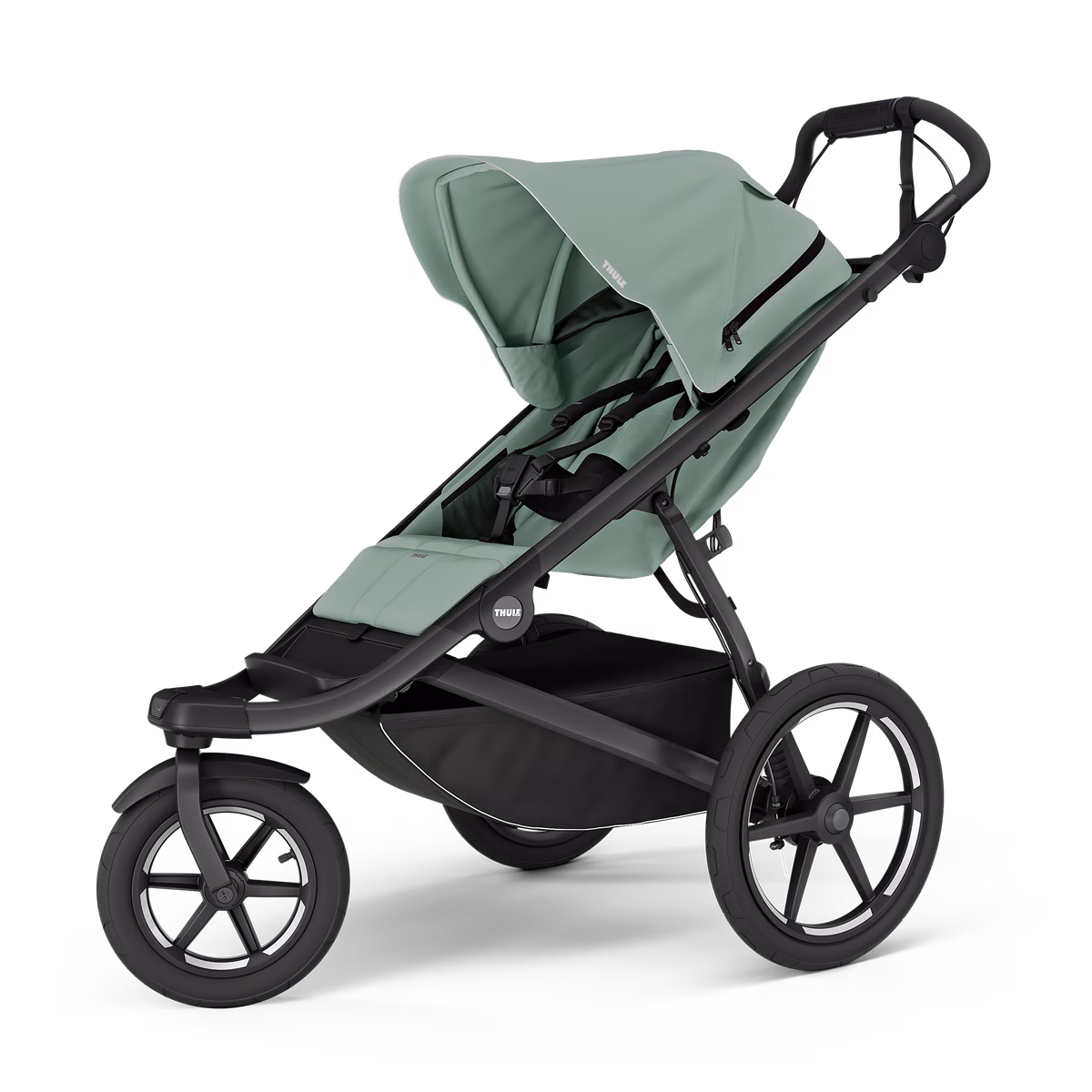 La poussette URBAN GLIDE 3 MIST GREEN est une poussette moderne à trois roues, avec une capote et un siège vert sauge, un châssis noir, de grandes roues arrière et un panier de rangement, sur fond blanc.