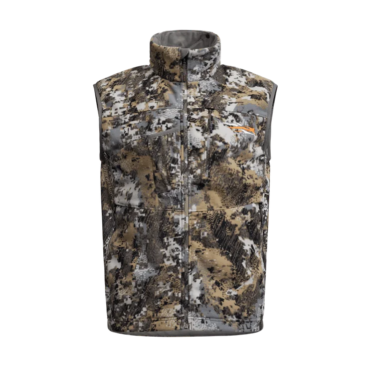 Gilet d'extérieur sans manches à col montant, à motif de camouflage numérique marron, beige, gris et blanc, avec plusieurs poches zippées sur le devant.