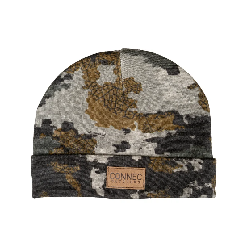 TUQUE ANTICOSTI MERINO JUNIOR : bonnet à revers, imprimé camouflage gris et marron, avec un écusson en cuir portant le logo sur le devant.