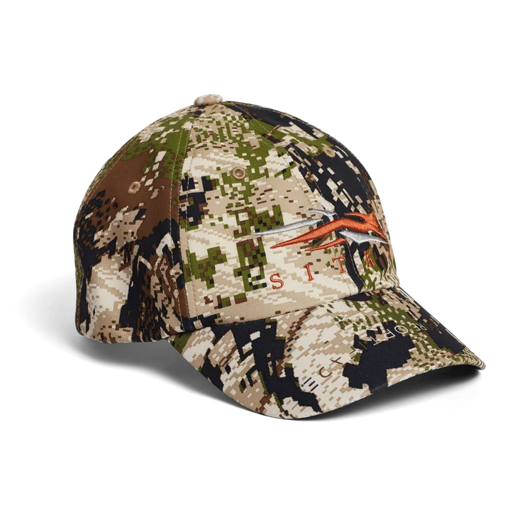 La TRAVERSE CAP est une casquette de baseball camouflage verte, marron et beige avec un logo d'animal stylisé orange au-dessus du mot "SITKA" sur le devant.