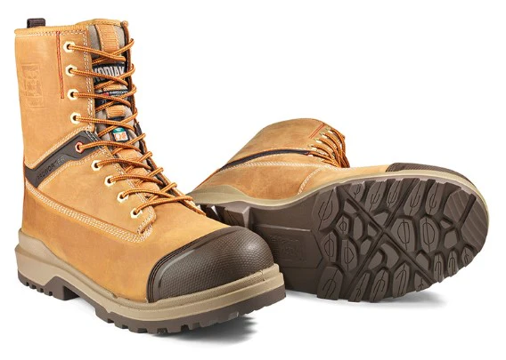 Une paire de bottes de travail beiges avec des semelles épaisses en caoutchouc texturé, des bouts renforcés marron et des lacets orange. Une botte est droite, l'autre est couchée sur le côté, laissant apparaître le motif de la semelle.