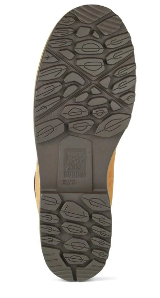 L'image montre la semelle en caoutchouc noir d'une botte avec un motif de bande de roulement texturé et robuste et le logo « KODIAK » en relief au centre.