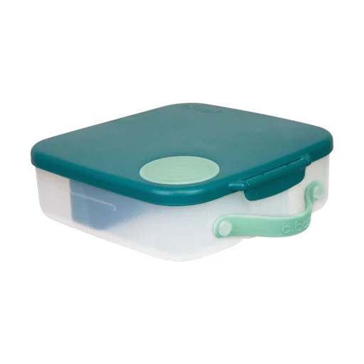La BOÎTE À LUNCH B.BOX est un récipient alimentaire rectangulaire en plastique, muni d'un couvercle bleu sarcelle et d'un loquet vert clair ; elle est représentée ici fermée.