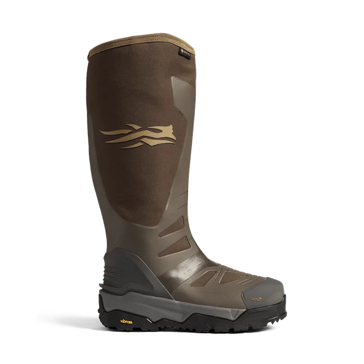 Une botte d'extérieur haute marron avec une semelle noire robuste, un logo doré sur le côté et une partie inférieure renforcée. Son design élégant est idéal pour les terrains difficiles ou les conditions humides.