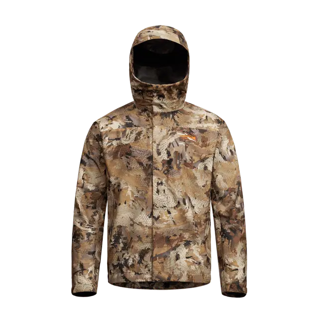 La veste DELTA LT est une veste à capuche et à manches longues, au motif camouflage décliné dans des nuances de marron, de beige et de vert, conçue pour les activités de plein air ou la chasse, et présentée sur un fond blanc uni.