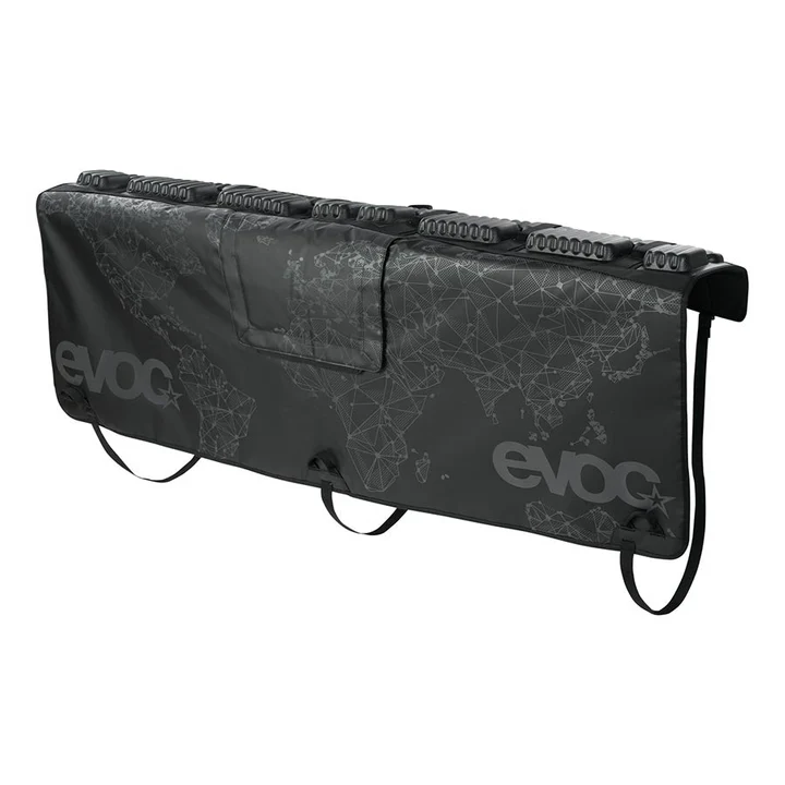 Le TAILGATE PAD CURVE 160CM est un tapis EVOC noir avec un design subtil de carte du monde, des sangles à boucle et un rembourrage, parfait pour protéger les vélos sur le hayon de votre camion.