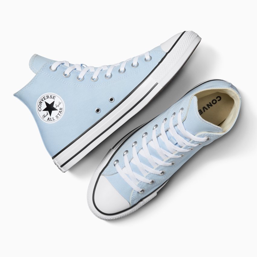 Une paire de baskets montantes Converse All Star bleu clair avec lacets blancs et semelles en caoutchouc. L'emblématique logo rond All Star est apposé sur le côté d'une chaussure. L'une est couchée sur le côté, l'autre à la verticale.