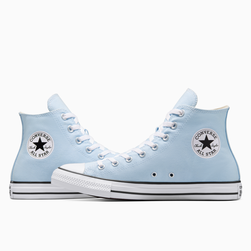 Deux Converse All Star montantes bleu clair se font face, affichant le logo circulaire emblématique au niveau de la cheville. Elles se détachent sur un fond blanc uni.