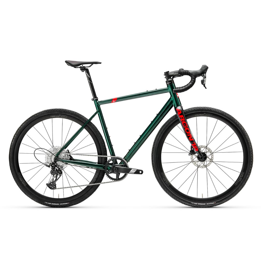Un vélo gravel vert foncé avec guidon de course, selle noire et roues noires. Le cadre arbore un logo rouge « ARGON 18 » sur le tube diagonal. Le vélo est équipé de freins à disque et d'un monoplateau avant.