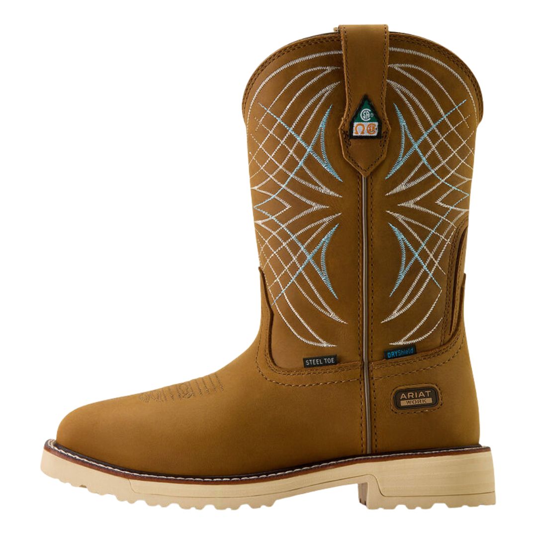 La BOTTE DE TRAVAIL ARIAT ACTIVATOR CSA POUR FEMME (LARGE) est une botte de travail à bout en acier de couleur beige avec une semelle légère, des coutures décoratives bleues et blanches sur la tige, des sangles de traction, la marque "Ariat" et une conception durable idéale pour les travaux difficiles.