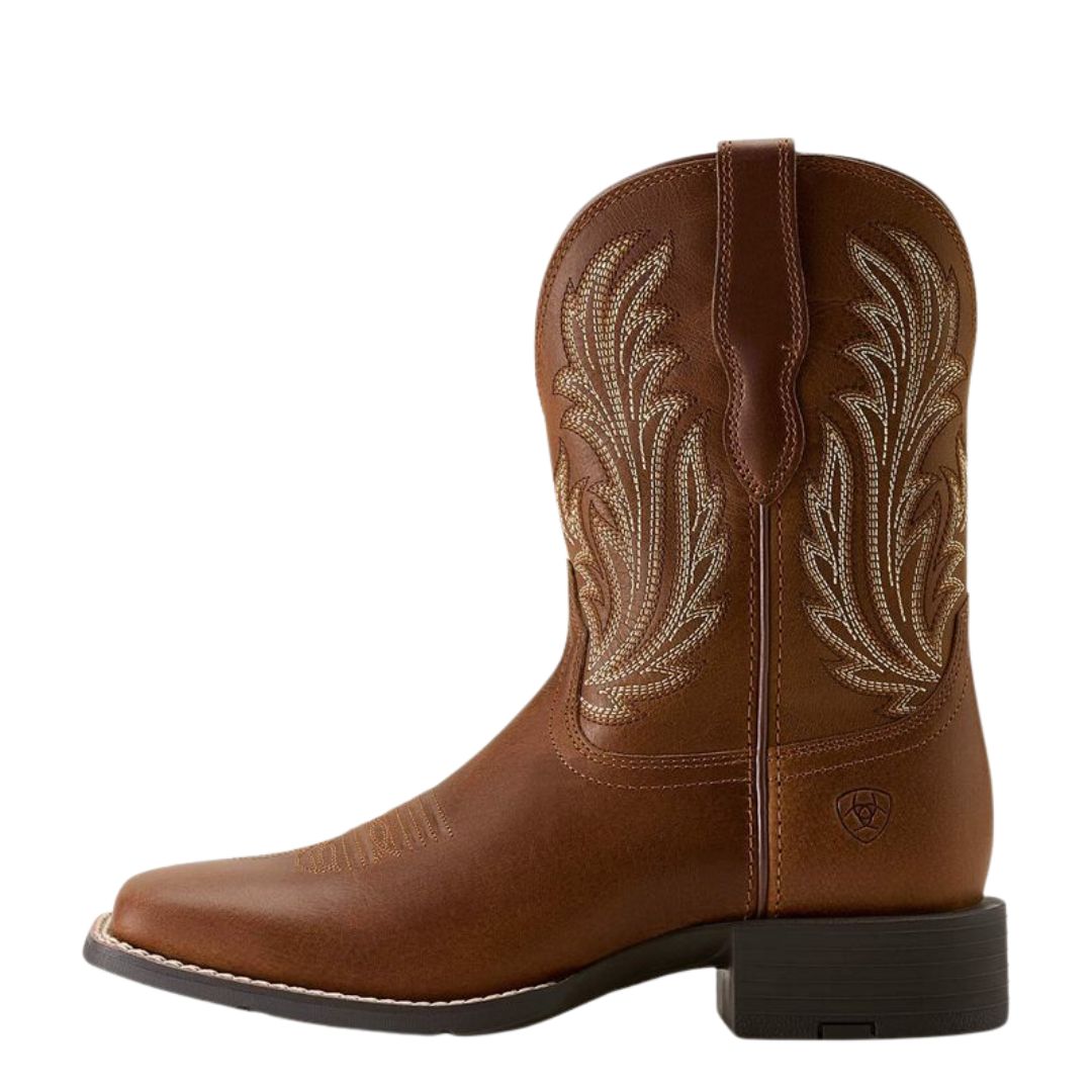 La WMS ROUND UP FILLY W-SQUARE WESTERN BOOT est une botte en cuir marron avec des coutures décoratives blanches, un bout carré, un talon bas, des lanières sur les côtés et un logo de marque visible près du talon.