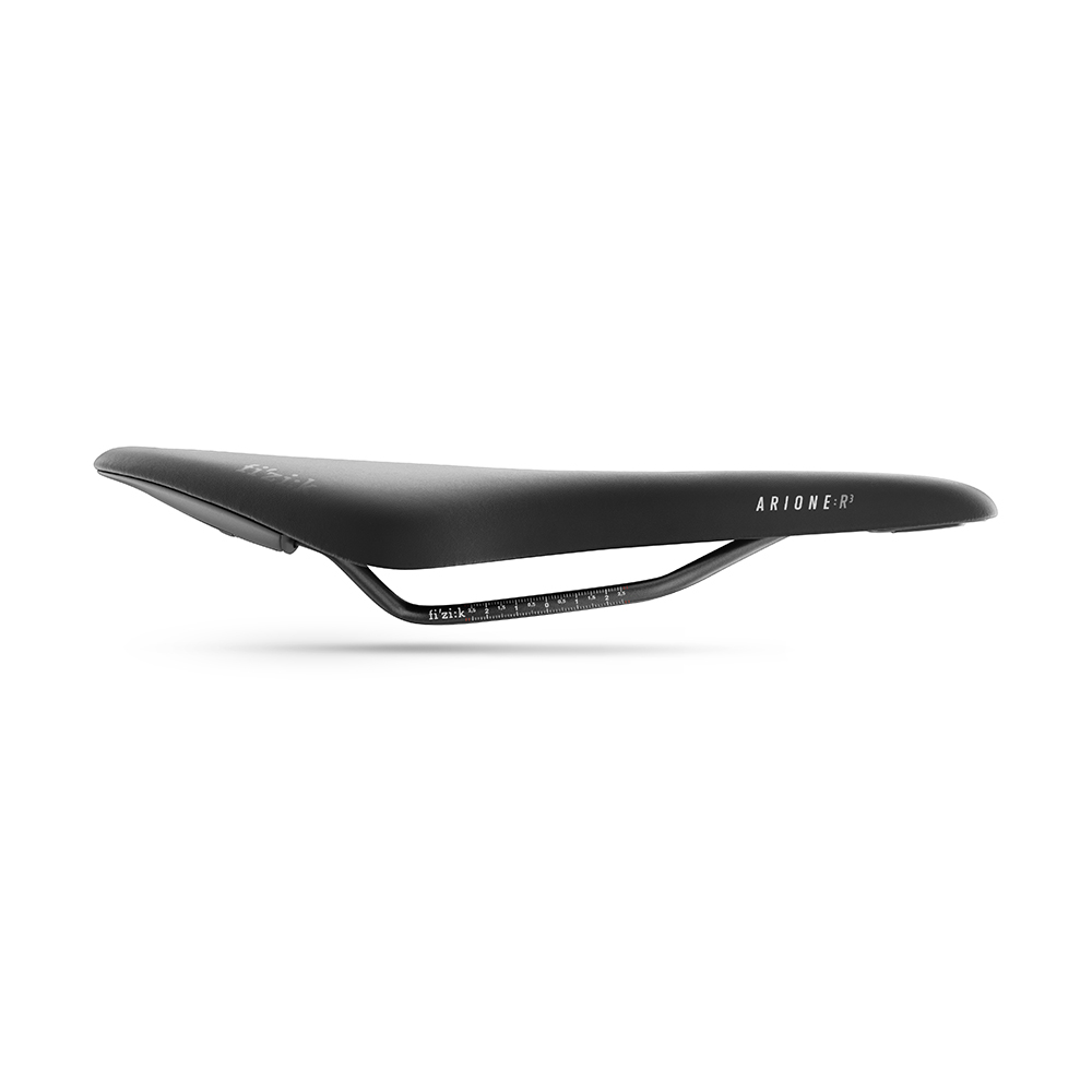 Une selle de vélo noire vue de côté, mettant en valeur son design élégant et son siège ergonomique incurvé. Le mot « Arione » est visible sur le côté. La selle est dotée d'un cadre léger soutenu par un rail métallique étroit en dessous.