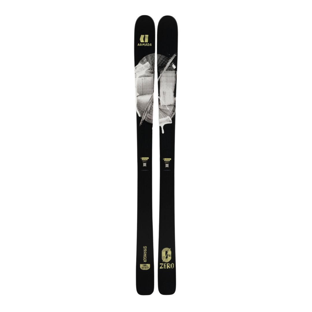 Paire de skis noirs avec des graphismes abstraits gris et blancs et un marquage jaune. Les skis sont exposés côte à côte sur un fond blanc.