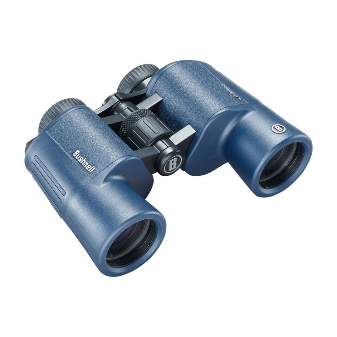 Une paire de jumelles Bushnell bleues avec des poignées texturées, de grands oculaires et une molette centrale de mise au point, vue d'un angle sur un fond blanc.