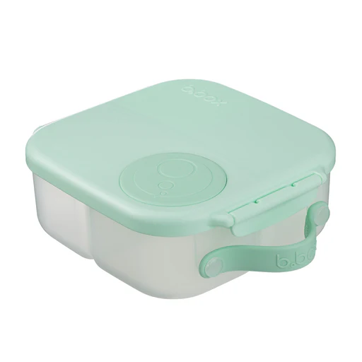 La BOÎTE À LUNCH B.BOX est une boîte à repas de couleur vert menthe et blanche, dotée de bords arrondis, d'une fermeture sécurisée et d'un motif circulaire sur le couvercle.