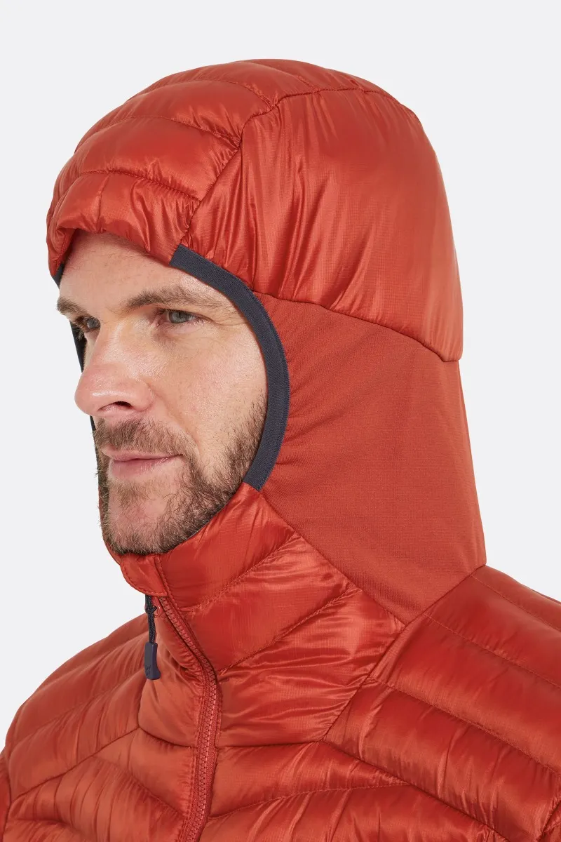 Une personne porte une veste orange à capuche avec une fermeture éclair sur le devant. La capuche couvre la majeure partie de la tête, laissant le visage visible de côté. L'expression de la personne semble neutre, avec une barbe claire. L'arrière-plan est blanc uni.