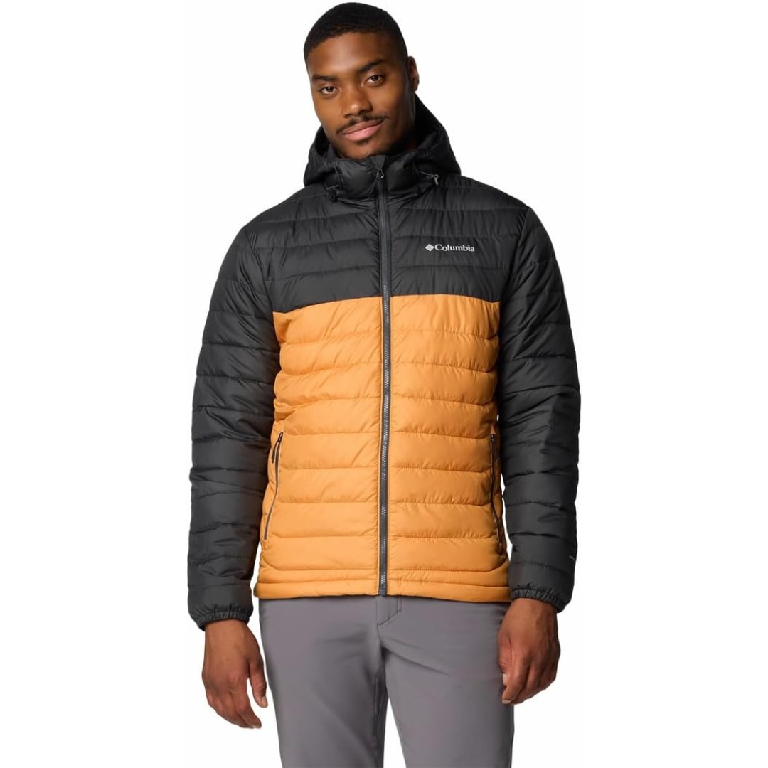 Un homme porte une veste d'hiver matelassée avec des parties noires et orange. La veste a une capuche et le logo Columbia sur la poitrine. Il pose devant un fond blanc uni.